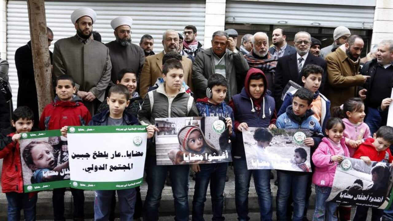 Supporters of Jemaah Islamiyah (Islamic Group) carry placards depicting pictures believed to be for children from the Syrian town of Madaya during a protest.