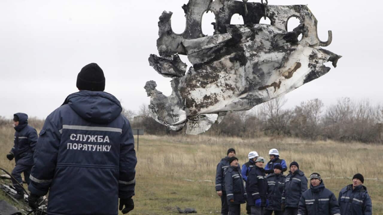 Workers remove wreckage from the MH17 crash site in Grabovo