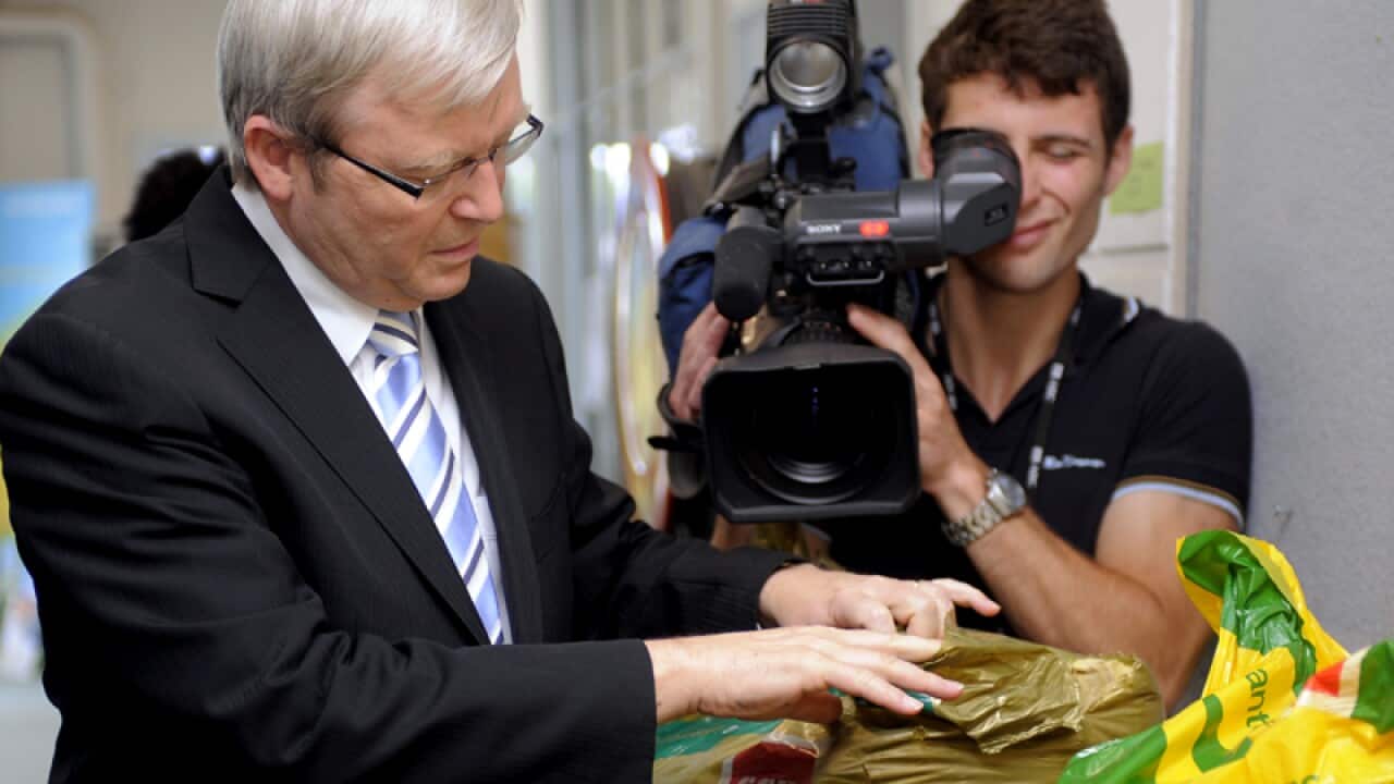 Kevin Rudd inspects a package of insulation batts