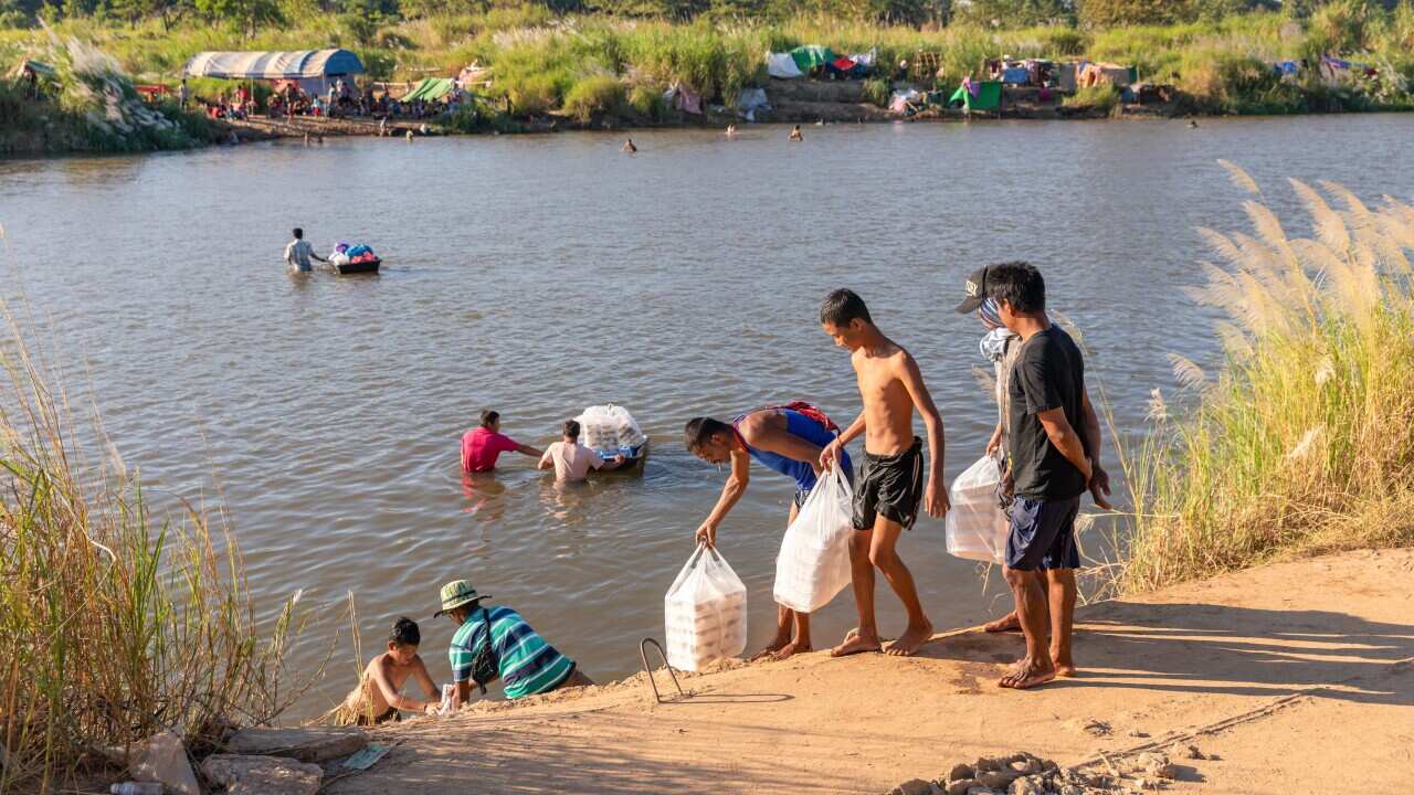 Karen people seen receiving donations through Moei River from Thailand. Evacuated Karen people live at a temporary campsite.