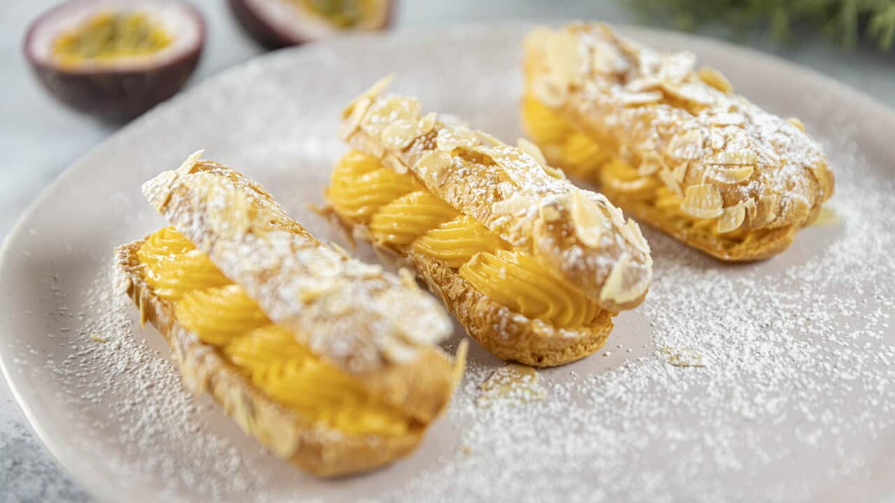 Split eclairs filled with piped passionfruit custard.