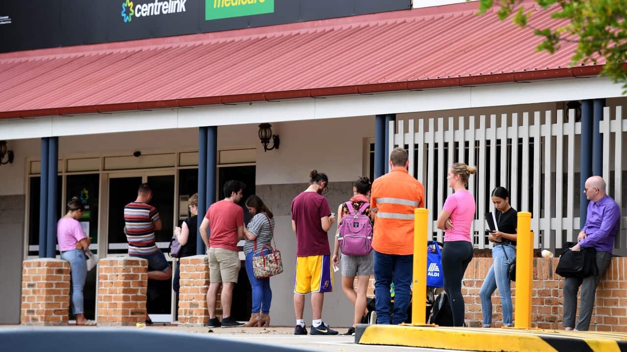 People are seen waiting in line at a Centrelink office