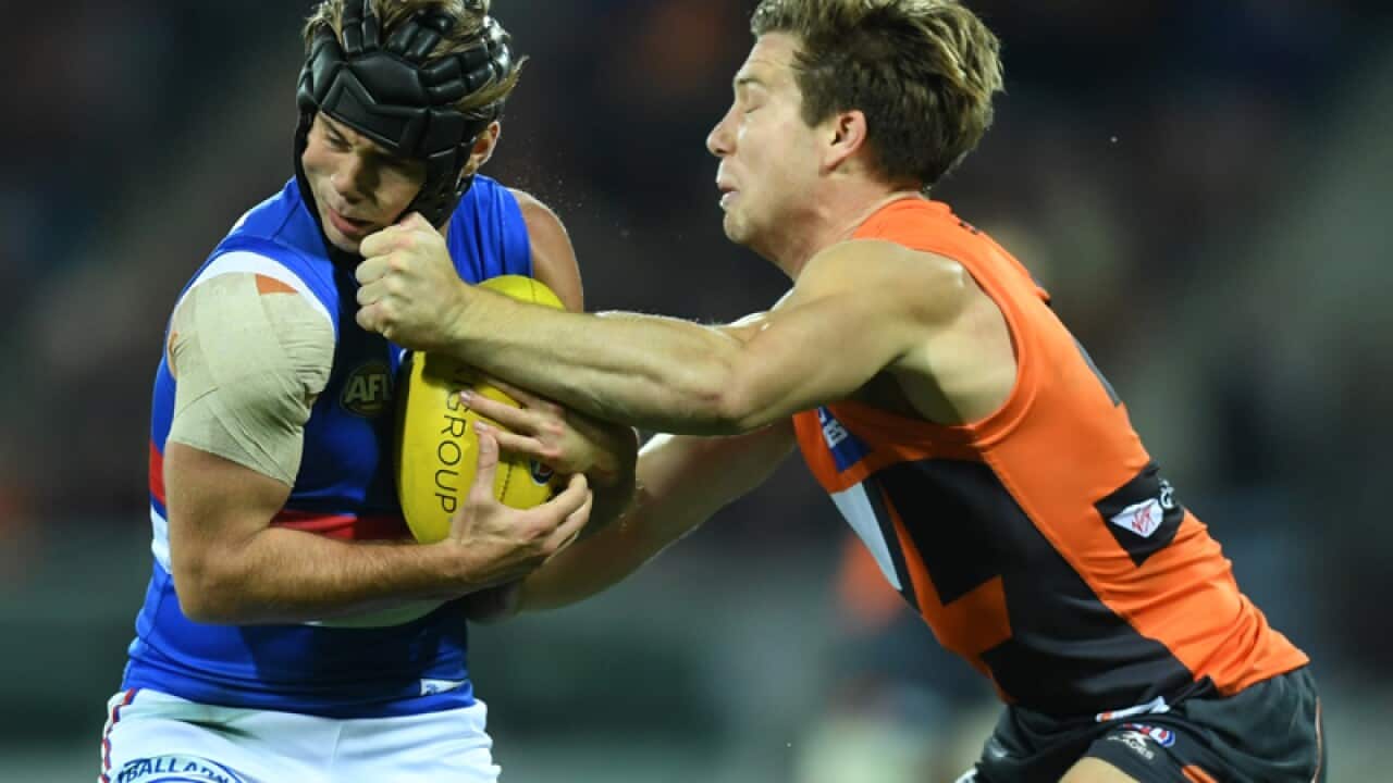 Toby Greene of the Giants (R) strikes Caleb Daniel of the Bulldogs