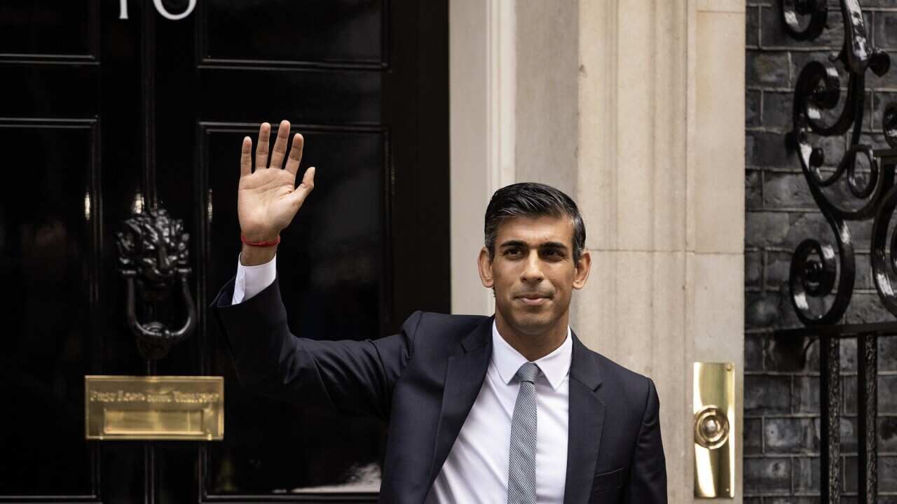 Rishi Sunak waves from outside 10 Downing Street - the official residence and the office of the British PM.
