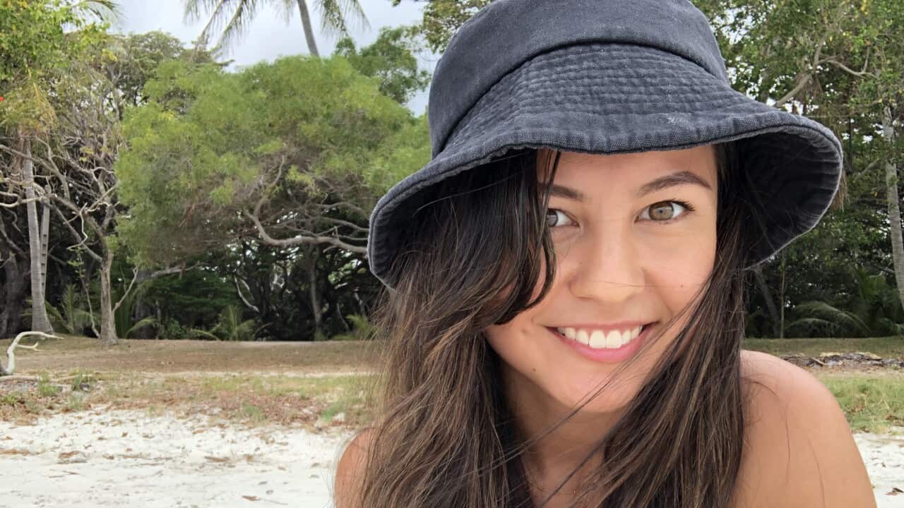 Emma Sullivan outdoors, wearing a black bucket hat smiling at the camera.