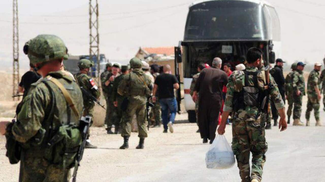 Russian soldiers and Syrian government forces gather as rebels leave