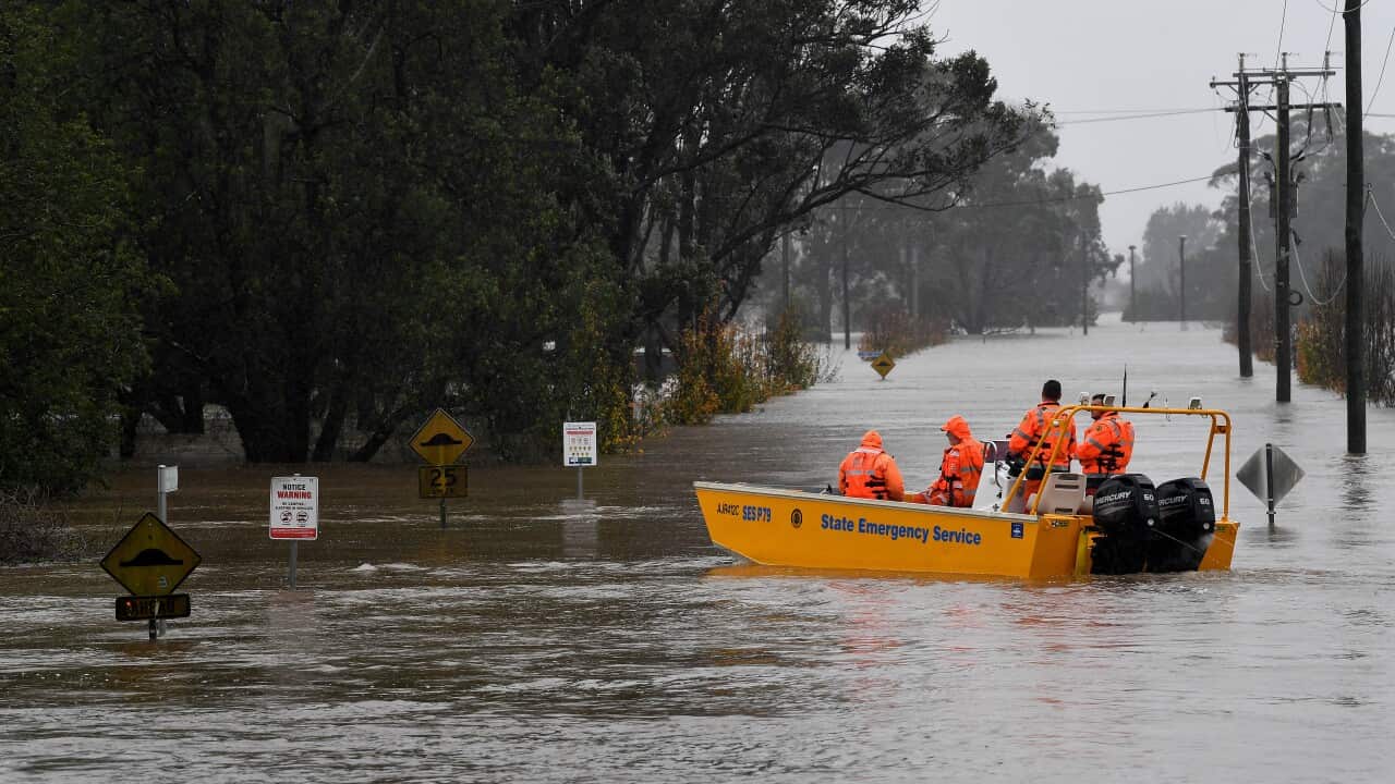 A NSW State Emergency Service (SES) crew is seen in a rescue boat as roads are submerged under floodwater from the swollen Hawkesbury River, in Windsor, north west of Sydney, Monday, July 4, 2022.