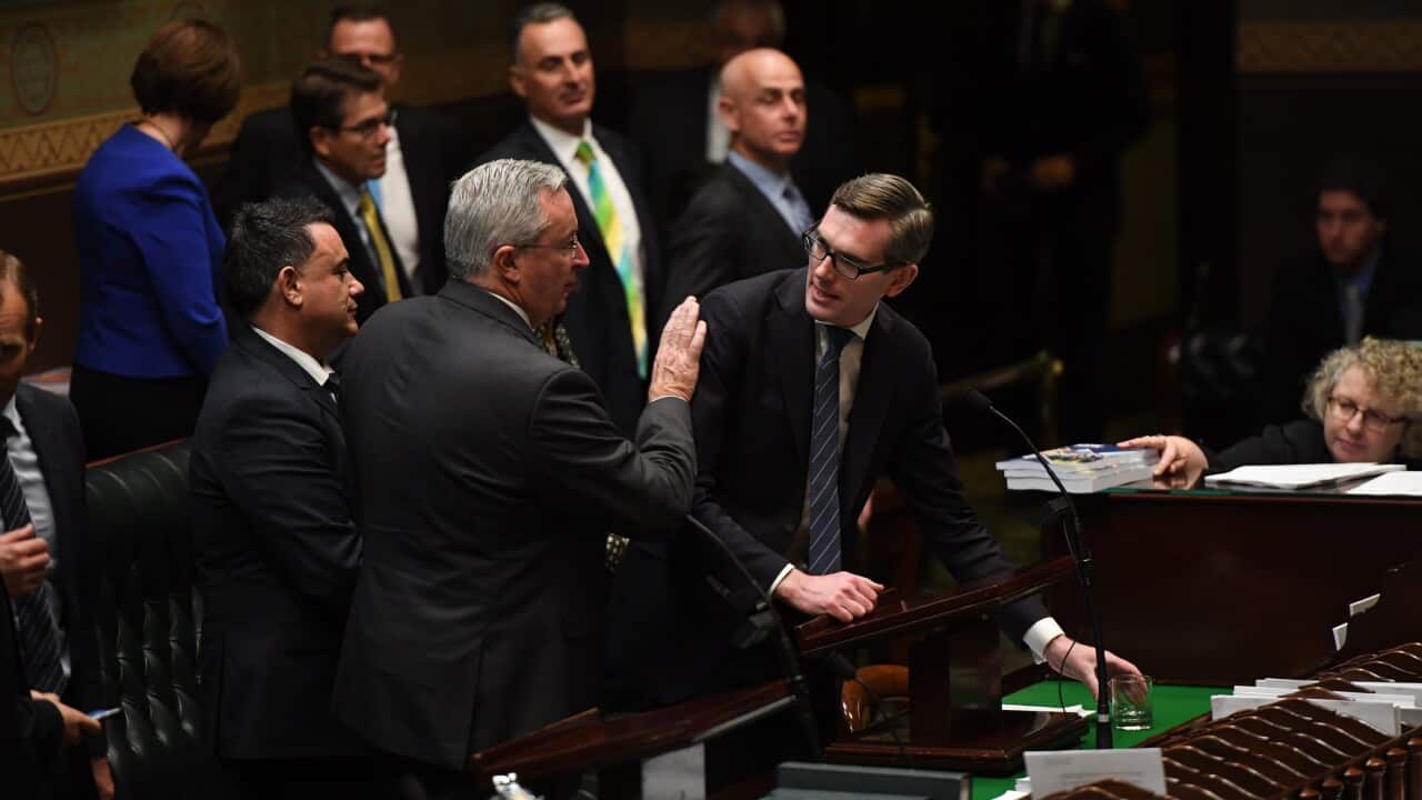 NSW Minister for Health Brad Hazzard (centre) congratulates NSW Treasurer Dominic Perrottet (right) after delivering the NSW State Budget.