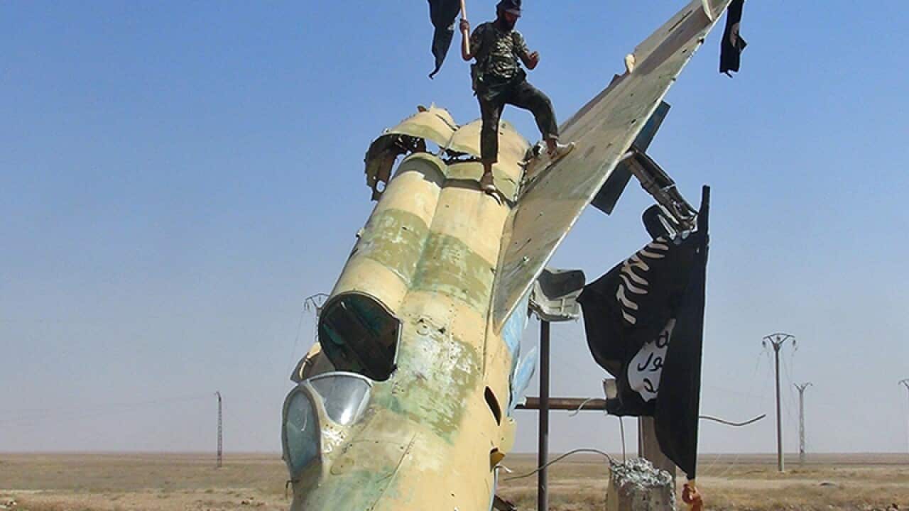 fighters of the Islamic State waving the group's flag
