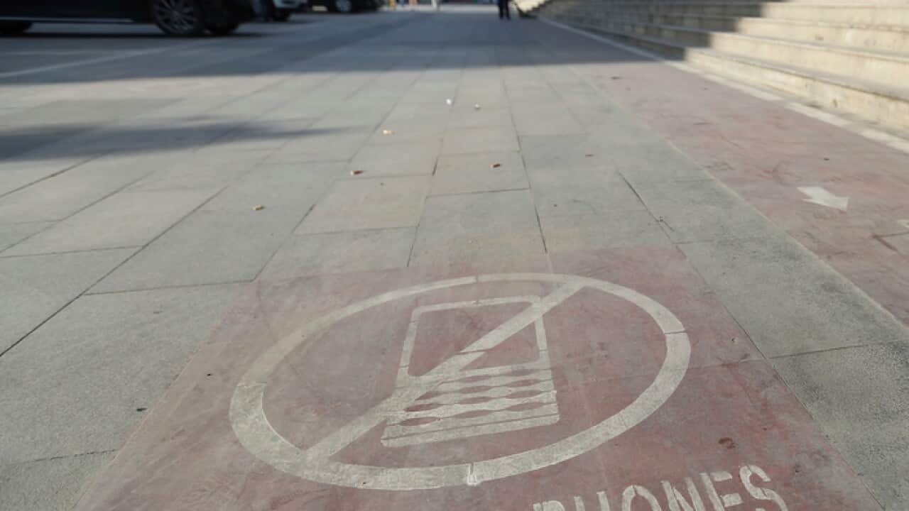 A signage of cellphone is pictured on the mobile phone sidewalk lane for phubbers in Xi'an city,