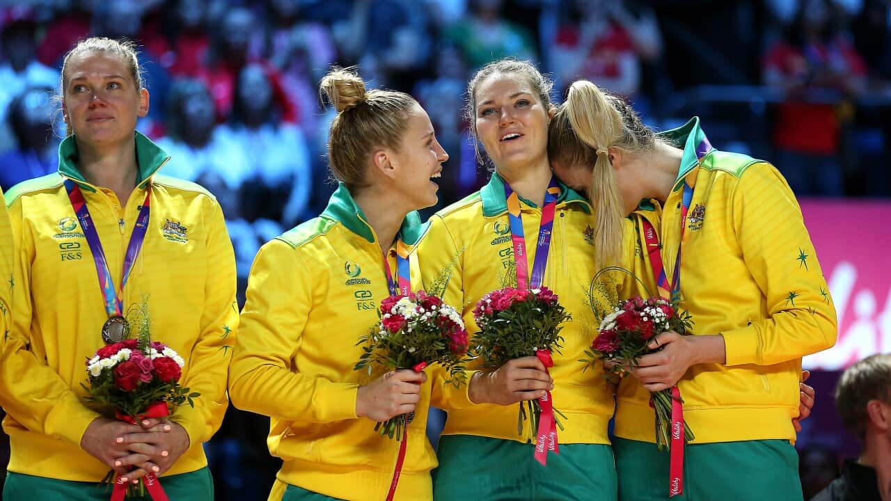 Australia's Gretel Tippett (centre) and Caitlin Bassett (right) celebrate with their silver medals after finishing second place during the Netball World Cup.