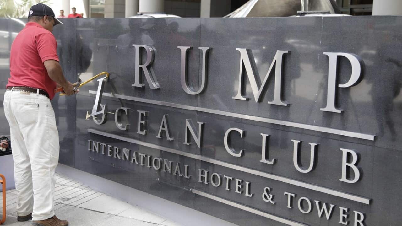 A man remove the word Trump of a marquee outside the Trump Ocean Club International Hotel and Tower in Panama City.
