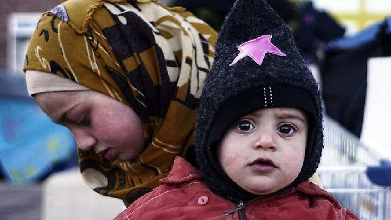 A migrant sister and brother from Syria outside a passenger terminal where migrants have found a shelter at the port of Piraeus. (Getty images)