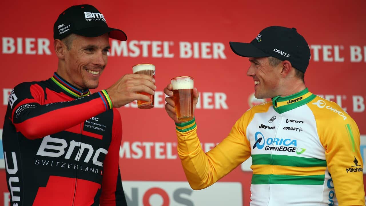 Philippe Gilbert and Simon Gerrans share a beer on the podium after the 2014 Amstel Gold Race