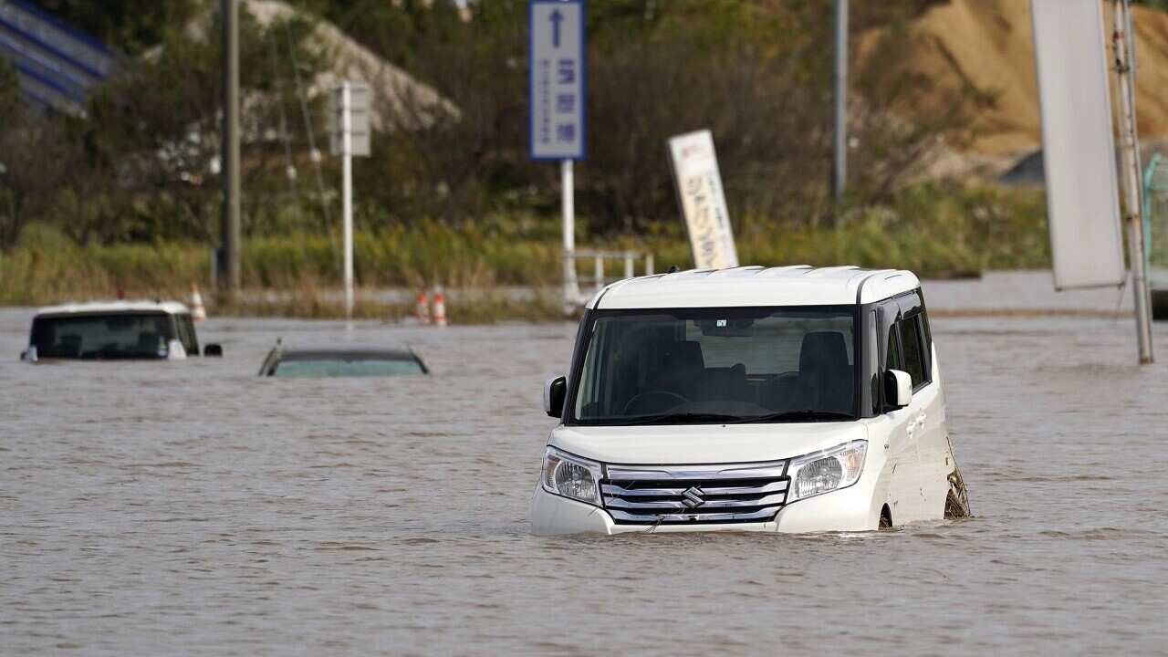 Vehicles are submerged in floodwaters after torrential rain in Sakura city on Saturday.