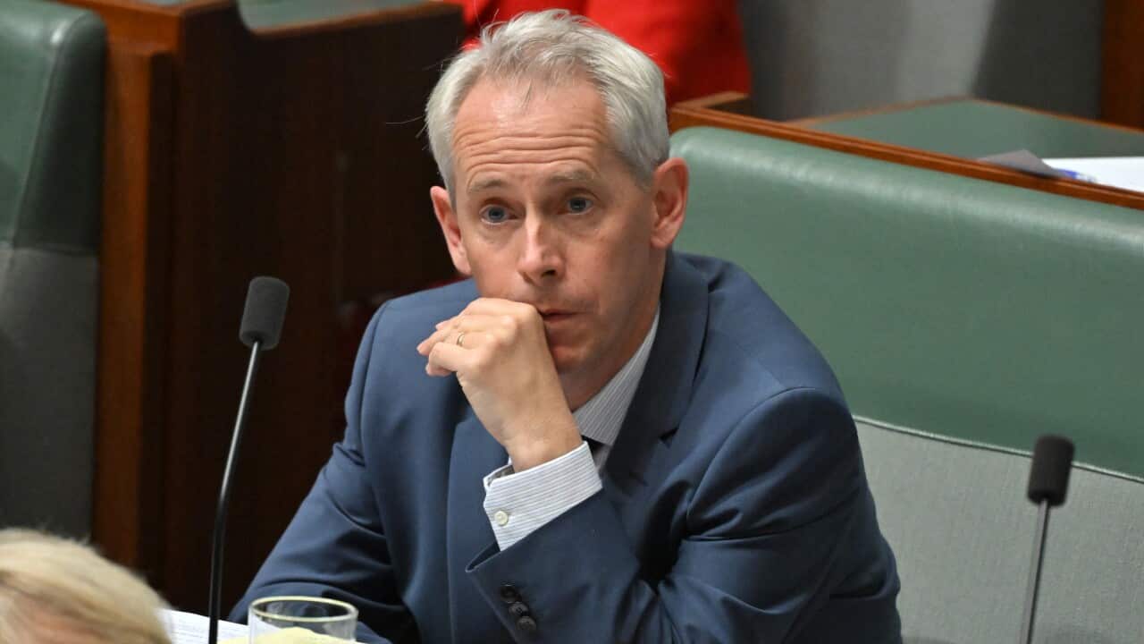 A man in a blue suit sitting on a green bench