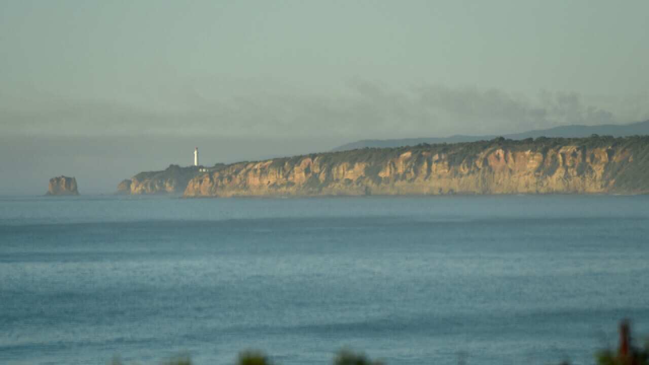 Smoke from the Otways bushfire rises over the Split Point Lighthouse