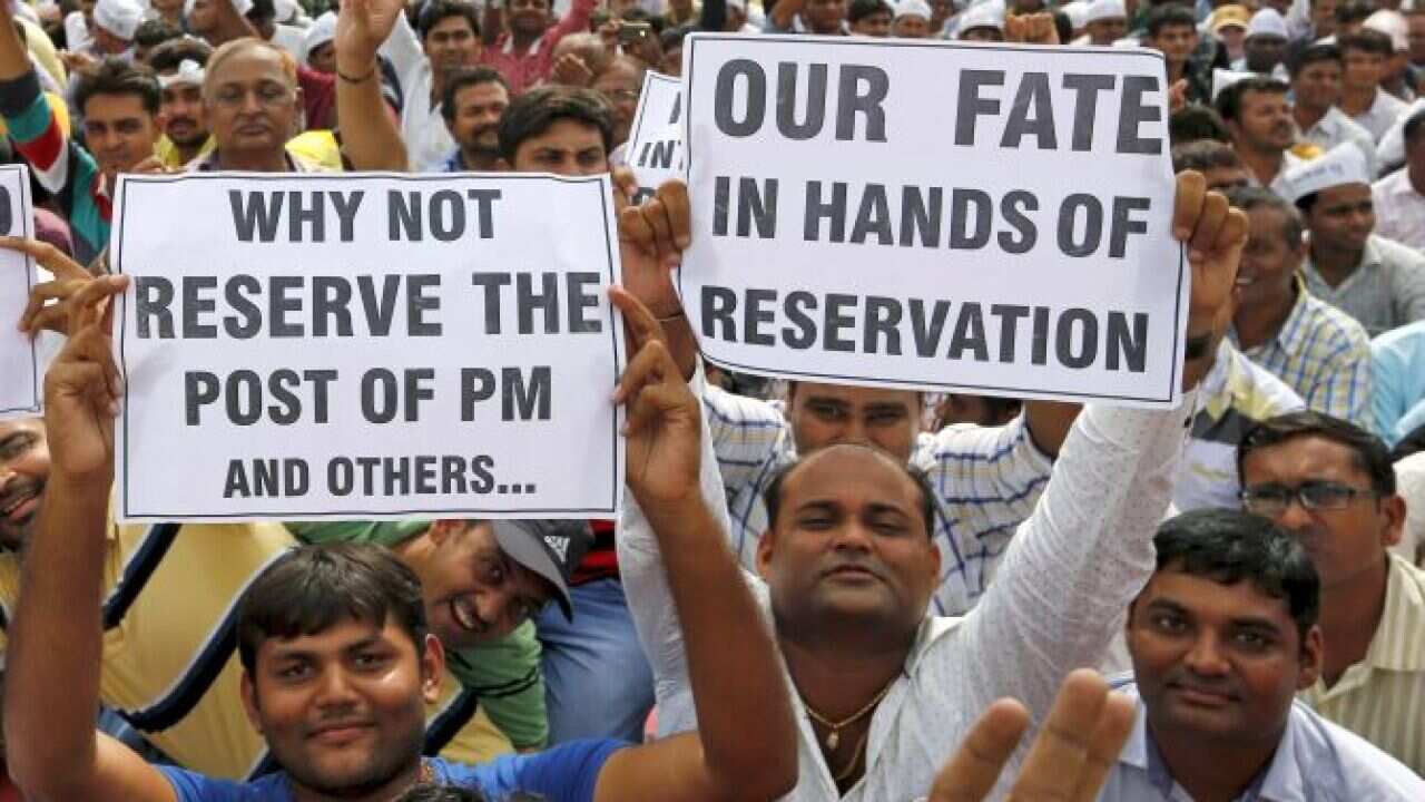 Members of Patel community display placards as they attend a protest rally in Ahmedabad