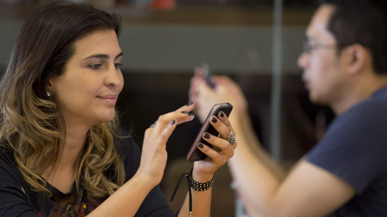 A woman checks her mobile phone