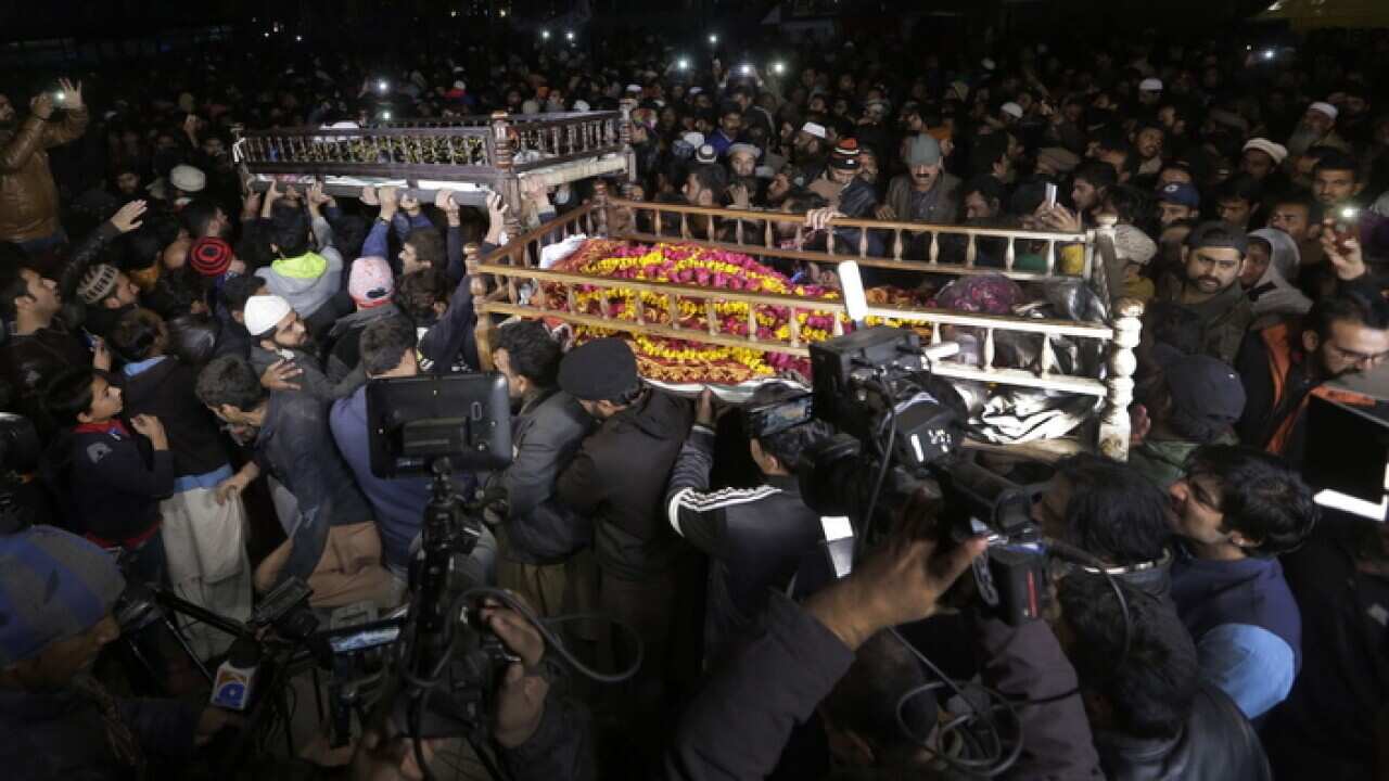 People attend the funeral of family members killed by police in Lahore, Pakistan