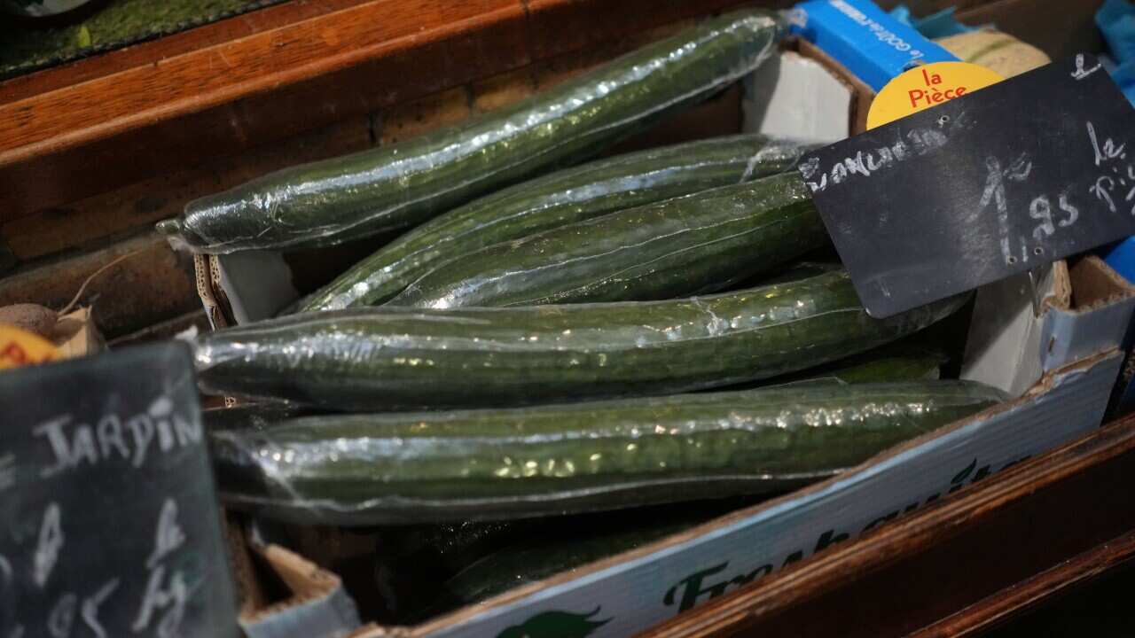 Cucumbers wrapped in plastic packaging are on display at a Paris supermarket on 31 December, 2021.