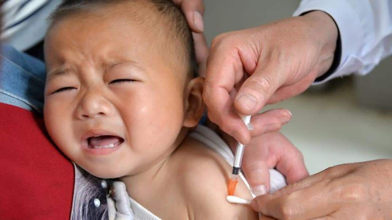 File image of a child reacting to a vaccine shot at a health station in Quzhou county,Hebei, China, (AAP)