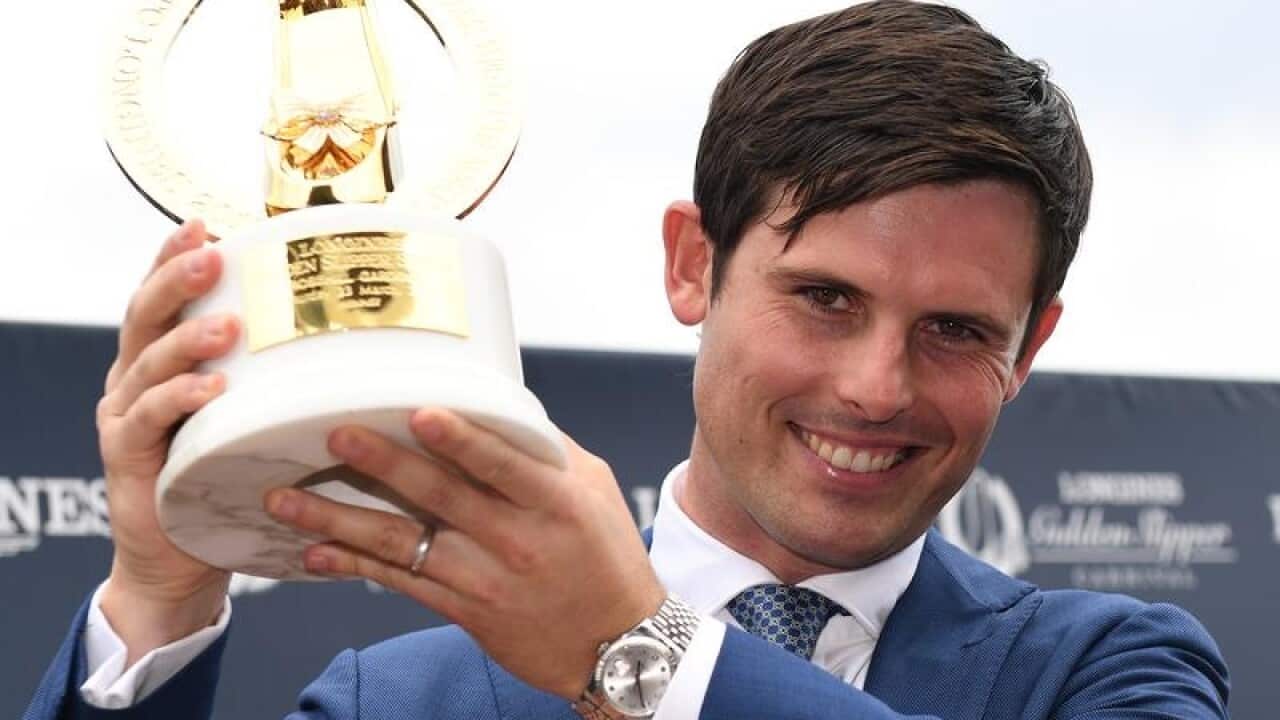 Trainer James Cummins lifts the Golden Slipper trophy