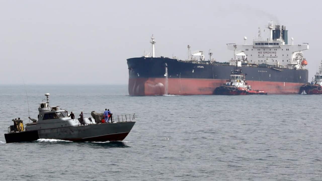 An Iranian military boat patrols next to the Artavil oil tanker in the Persian Gulf