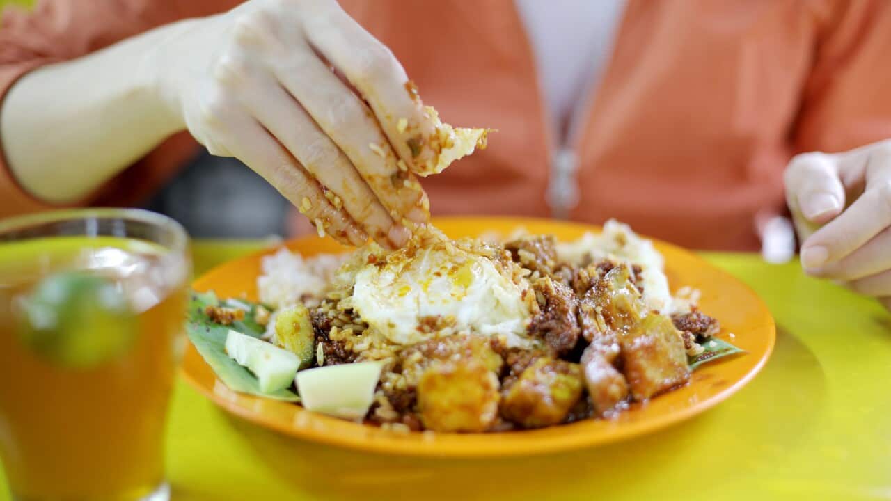 Woman eating nasi lemak in Malaysia