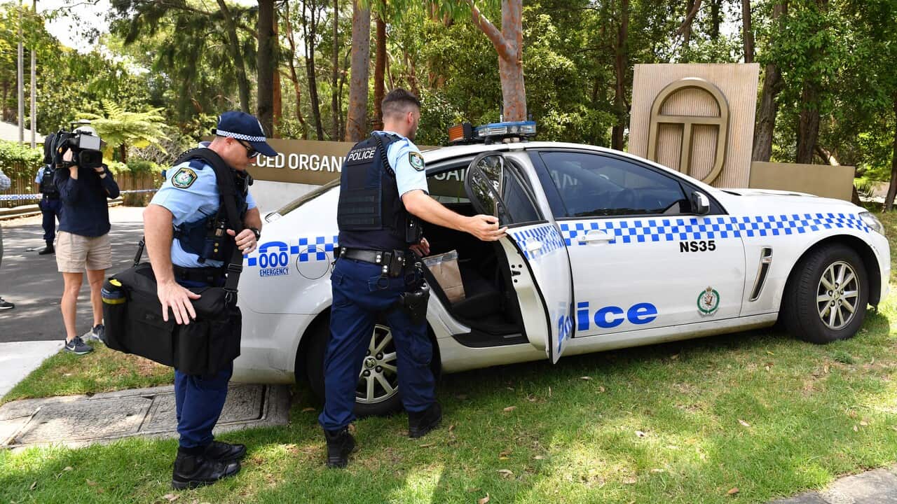NSW Police place evidence bags into a car at the scene of a double stabbing at the Church of Scientology headquarters at Chatswood in Sydney.