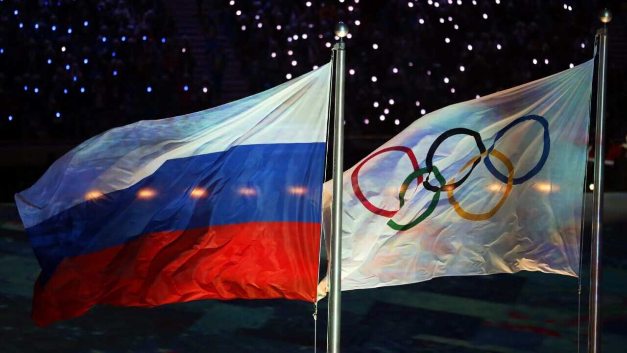 A file picture of the Olympic flag (R) and the Russian flag (L) during the Closing Ceremony of the Sochi 2014 Winter Olympics
