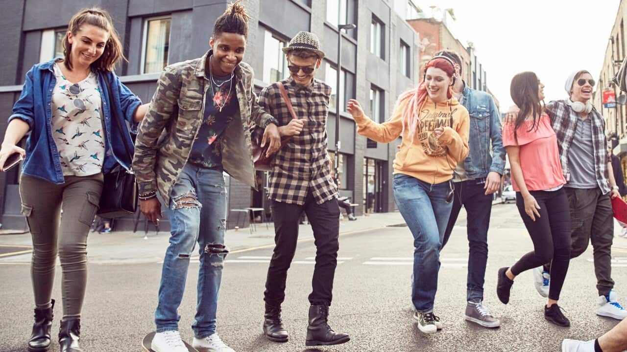 Teenage friends walking along street