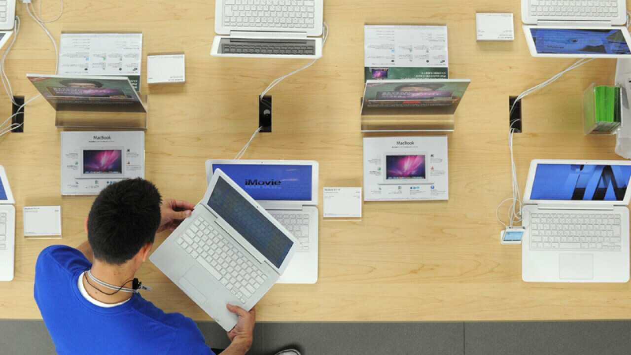 An Apple employee connects a computer