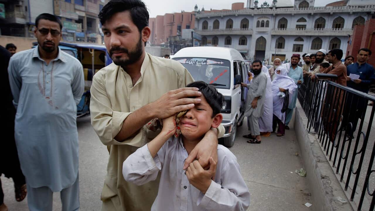 A man helps an injured boy to a hospital after an earthquake hit Peshawar, Pakistan, Sunday, April 10, 2016.