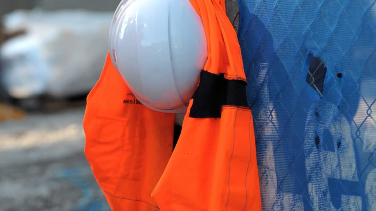 A hard hat and a high visibility vest at a building site