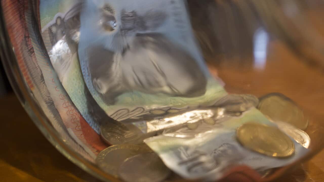 A tip Jar with money it at a restaurant