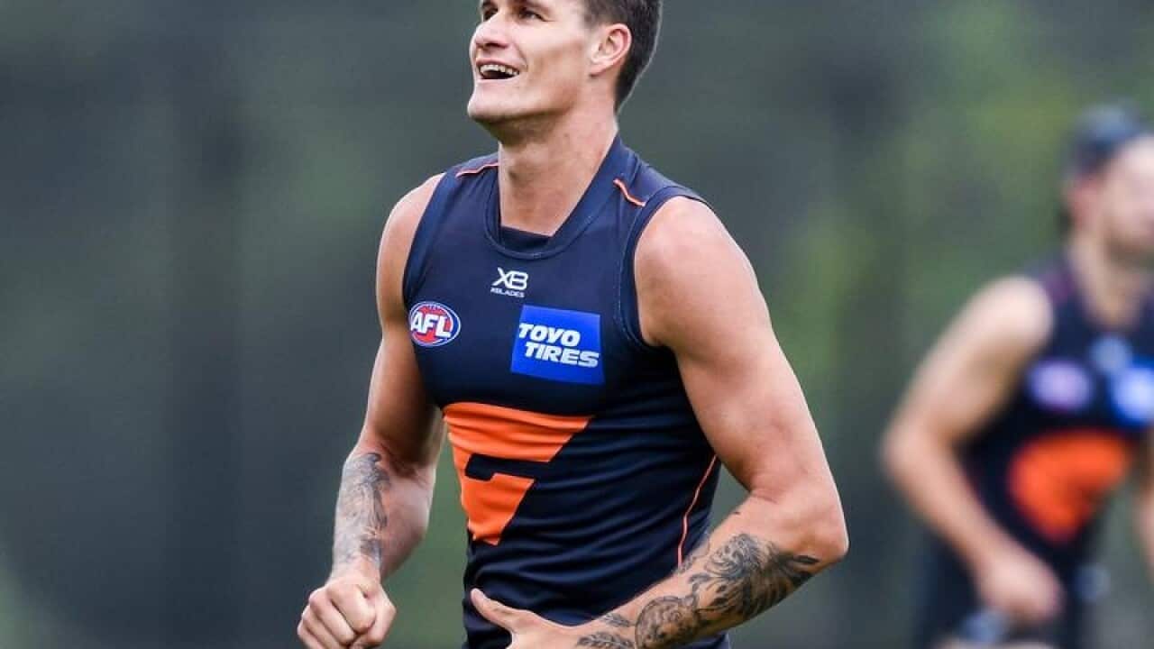 AFL Giants player Rory Lobb smiles as he runs.
