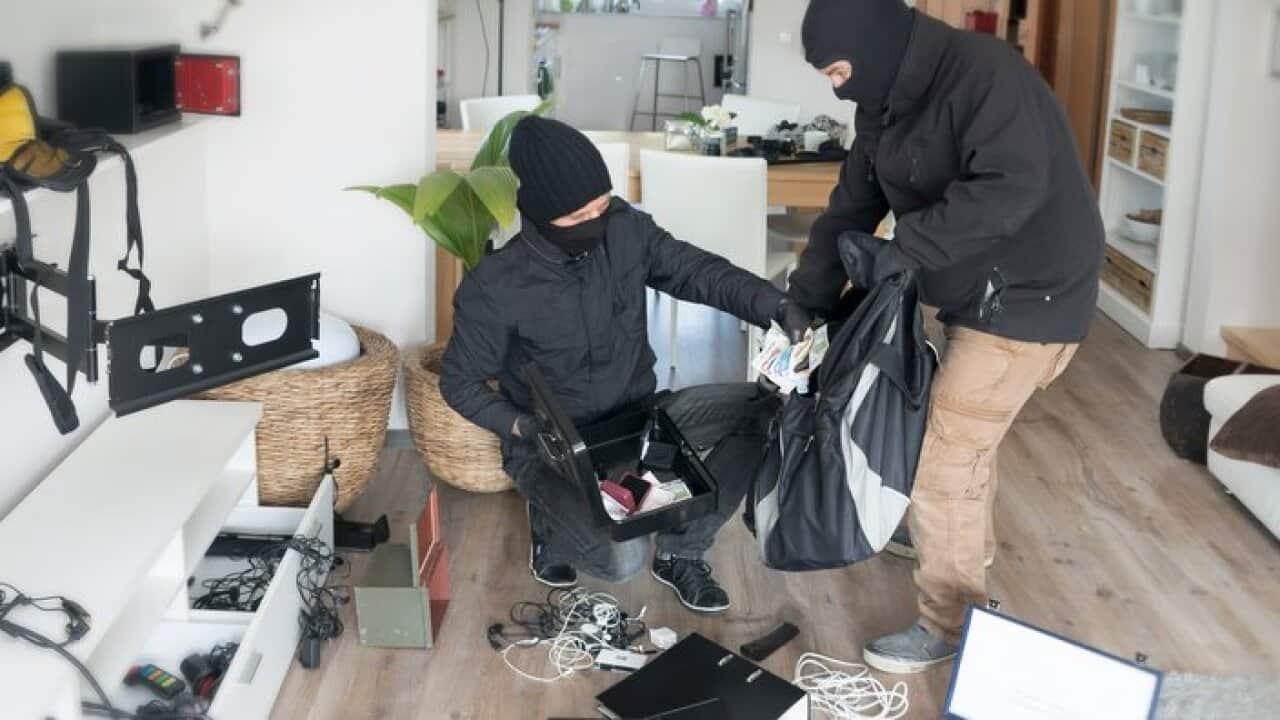 Two burglars at work in an one-family house at daytime
