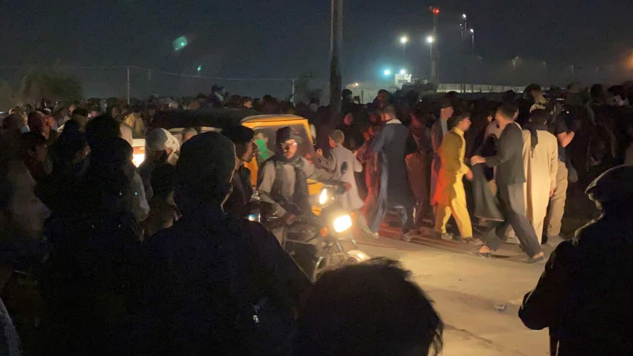 People wait to enter to the Hamid Karzai International Airport