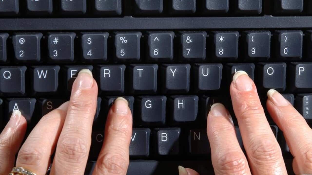 Two hands typing on a computer keyboard
