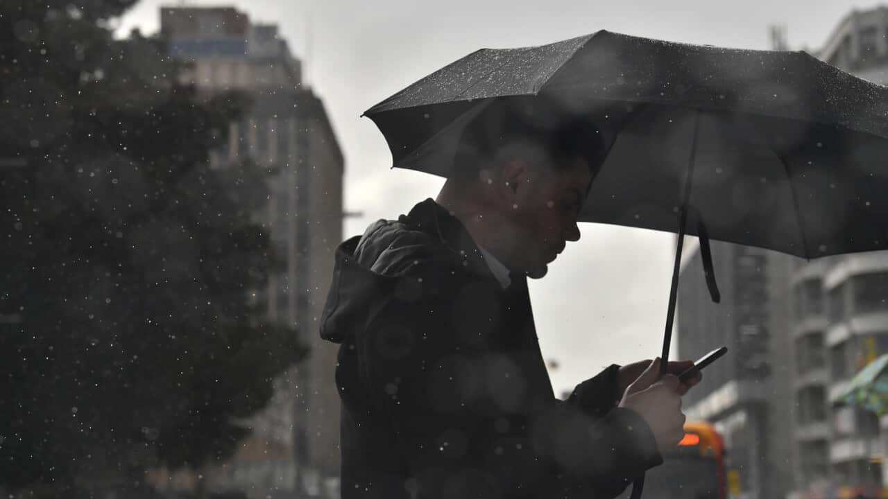 A man is seen crossing the road on a rainy day in Adelaide.