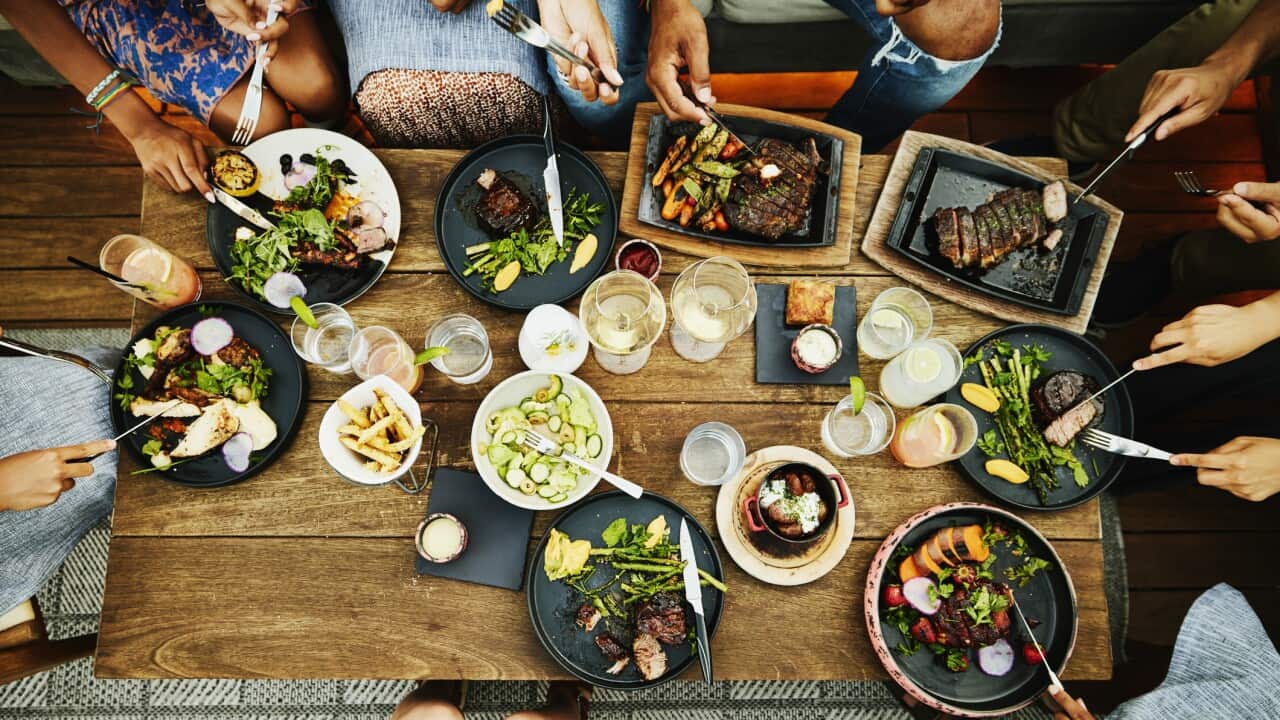 Medium overhead shot of families sharing dinner at outdoor restaurant