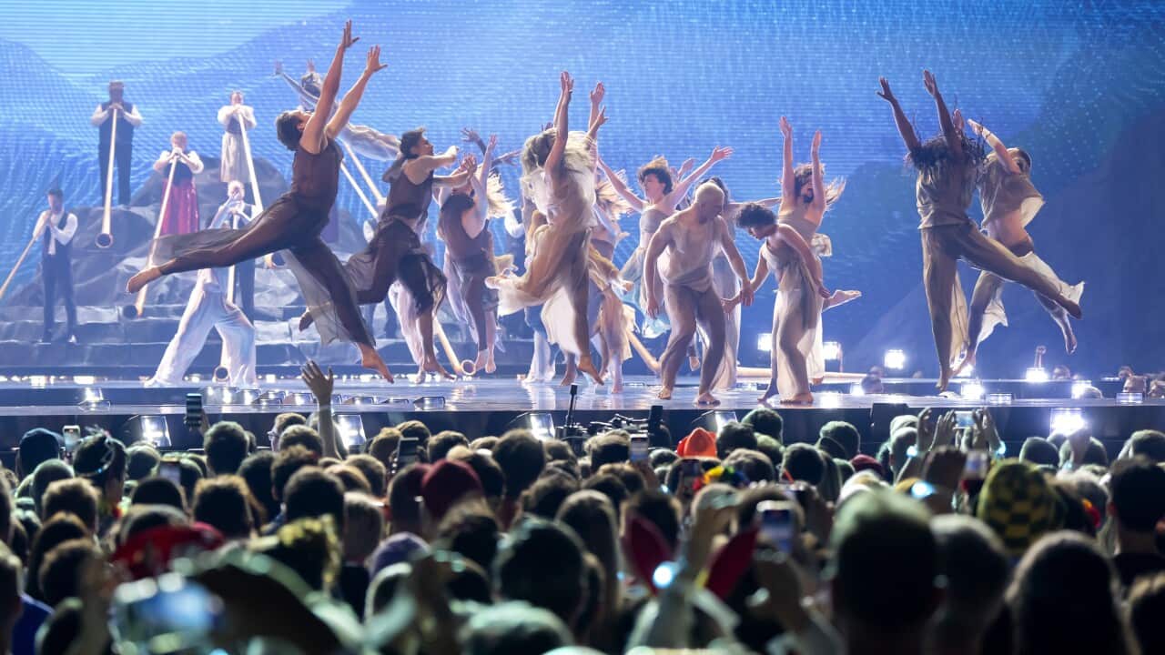 Dancers on stage jumping will a crowd cheers