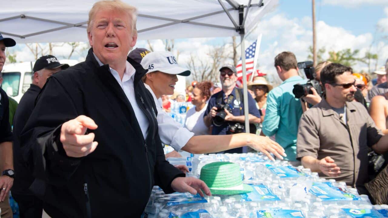 US President Donald Trump and First Lady Melania Trump hand out bottles of water as they tour damage from Hurricane Michael in Lynn Haven, Florida.