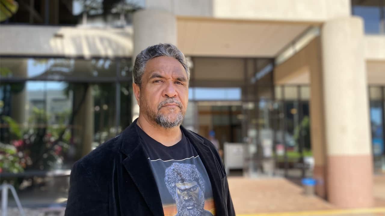 a man looks seriously into the camera