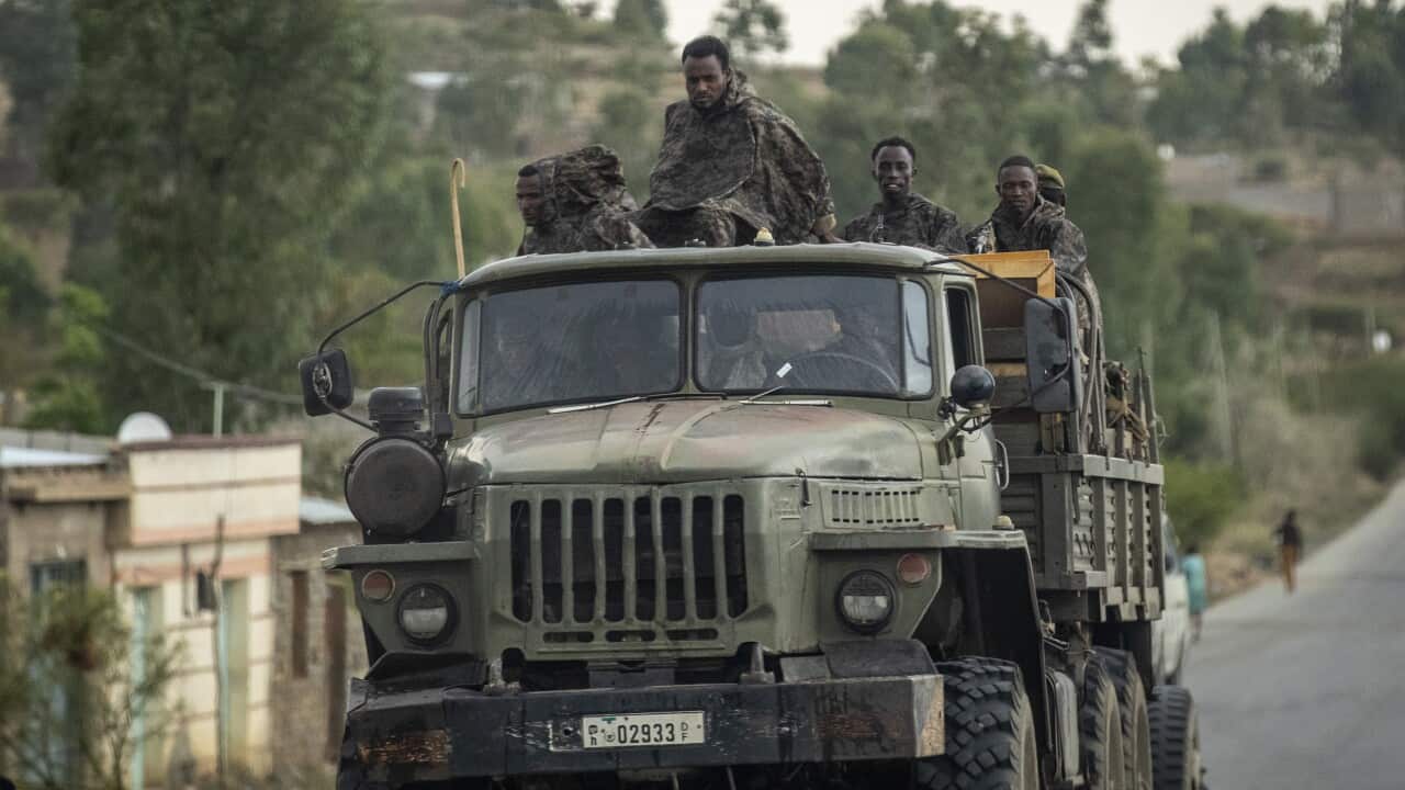 Ethiopian government soldiers ride in the back of a truck on a road leading to Abi Adi, in the Tigray region of northern Ethiopia on May 11, 2021.
