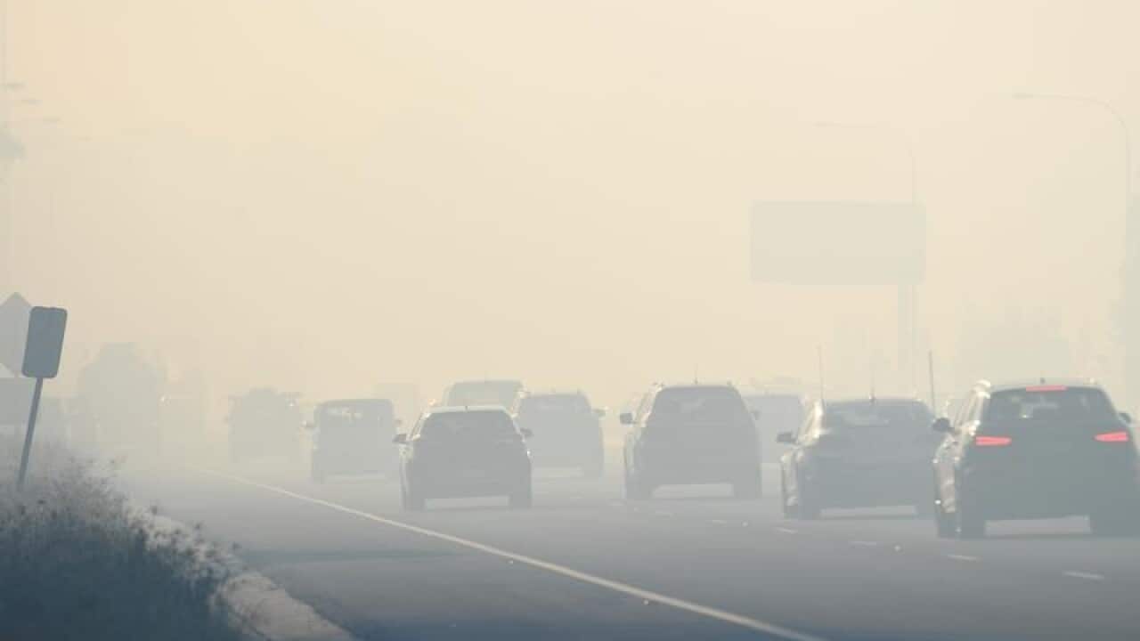 Motorists drive through smoke caused by bushfires on the M5,