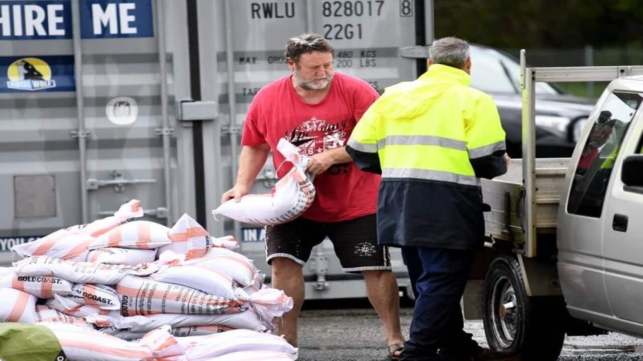 A man loads up sandbags to his car at Pimpama on the Gold Coast