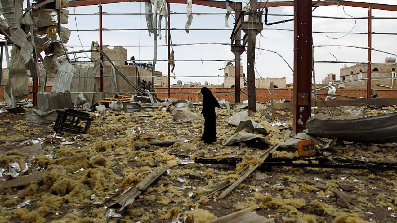 A Yemeni woman inspects the damage at a factory allegedly targeted by Saudi-led airstrikes in Sana'a, September 2016.