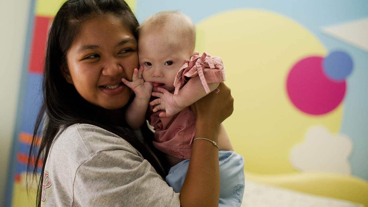 Thai surrogate mother Pattaramon Chanbua (L) holds her baby Gammy, born with Down Syndrome, at the Samitivej hospital, Sriracha district in Chonburi province on August 4, 2014. (AFP)